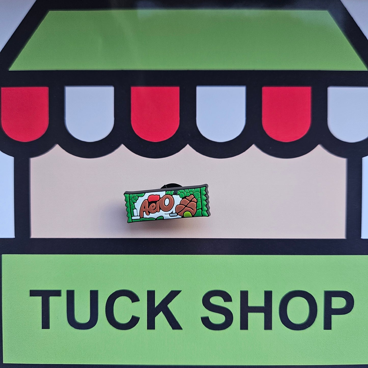 Aero chocolate bar croc charm on a 'Tuck Shop' sign with colorful awning